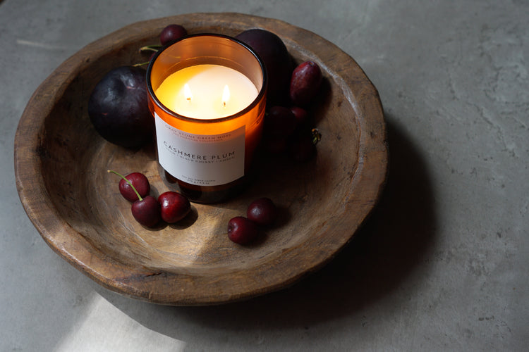 ripe mangos and a mango coconut candle with a coconut in the background